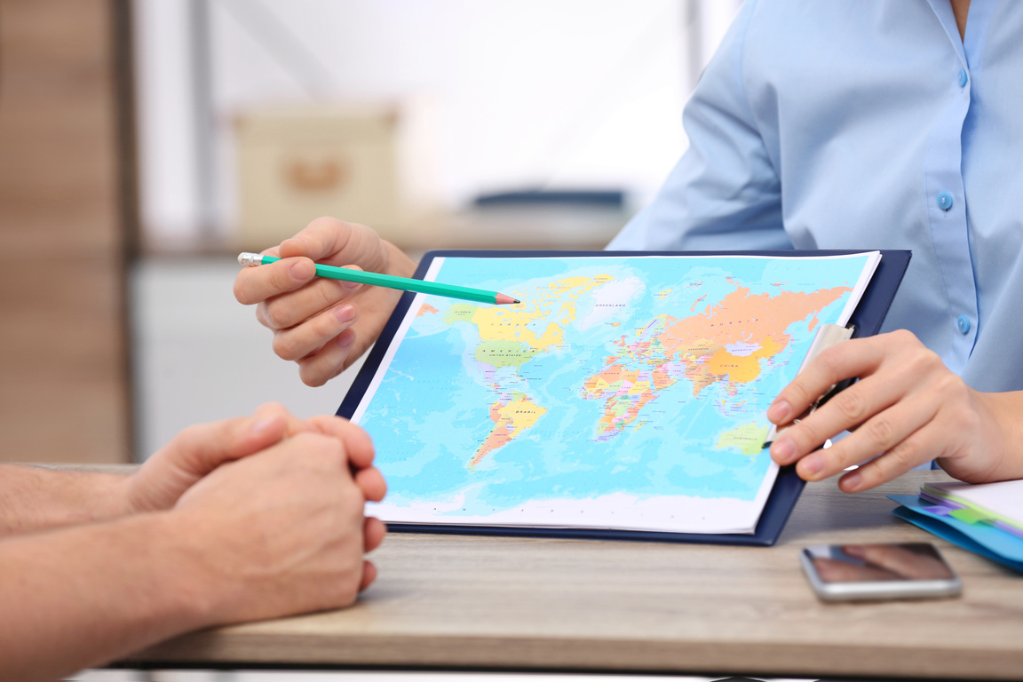 Female Manager Consulting Client in Travel Agency, Closeup